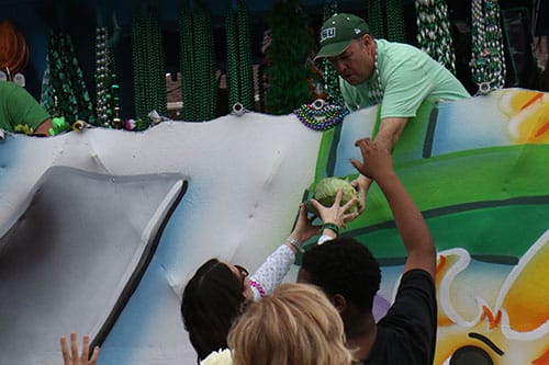 Debbie Flanagan gets a cabbage from a float during the 66th annual Irish Channel St. Patrick's Day Parade on Saturday, March 12. (Zach Brien, UptownMessenger.com)