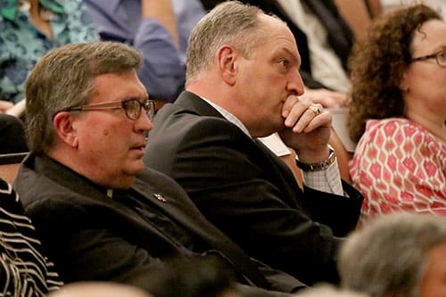 Rev. Kevin Wildes, S.J., Loyola University president, left, and Louisiana Gov. John Bel Edwards, right, listen to James Carville and Mary Matalin speak about the 2016 Presidential election in Rousell Hall. Carville, a Democrat, and Matalin, a Conservative, are two prominent speakers in their respective political circles. (Zach Brien, UptownMessenger.com)