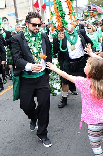 A member of the Irish Channel St. Patrick's Day club hands out a flower during the 66th annual Irish Channel St. Patrick's Day parade on Magazine St. on Saturday, March 12. (Zach Brien, UptownMessenger.com)