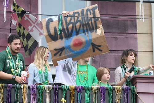 Onlookers on the balcony above Theo's Pizza ask for a cabbage as floats roll down Magazine street in the 66th annual Irish Channel St. Patrick's Day parade on Saturday, March 12. (Zach Brien, UptownMessenger.com)