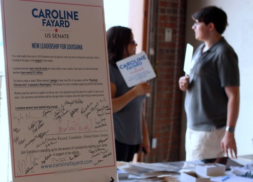 A placard at the rally displays Caroline Fayard's pledge to take only 65 percent of her salary until Congress passes a law improving women's wages. (Robert Morris, UptownMessenger.com)