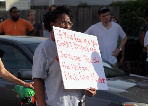 A protester holds a sign during a rally demanding justice for Eric Harris. (Robert Morris, UptownMessenger.com)