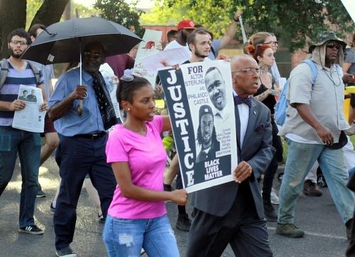 Protesters carry a sign as they march toward Lee Circle during a rally demanding justice for Eric Harris. (Robert Morris, UptownMessenger.com)