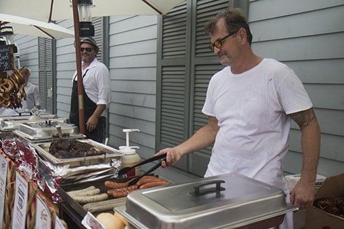 Greg James, left, of Bratz Y'all, prepares some food before the parade rolls. The Krewe of O.A.K. celebrated the 30th anniversary of Mid Summer Mardi Gras with the theme "Get Wet". (Zach Brien, UptownMessenger.com)
