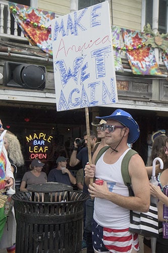 Dustin Cook holds up a "Make America Wet Again" sign outside of the Maple Leaf Bar. The Krewe of O.A.K. celebrated the 30th anniversary of Mid Summer Mardi Gras with the theme "Get Wet". (Zach Brien, UptownMessenger.com)