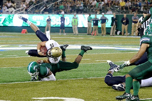 Tulane linebacker Nico Marly upends Navy quarterback Will Worth. Navy defeated Tulane 21-14 at Yulman Stadium. (Zach Brien, UptownMessenger.com)