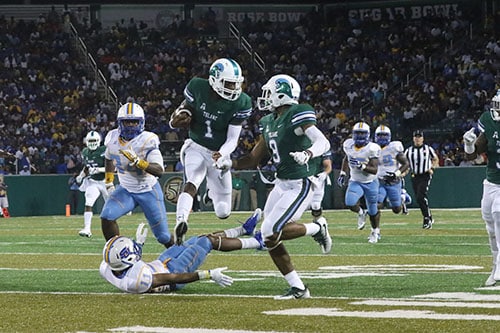 Tulane quarterback Johnathon Brantley hurdles a Southern defender on a lengthy run in the second quarter. Tulane defeated Southern University 66 to 21 at their home opener at Yulman Stadium. (Zach Brien, UptownMessenger.com)