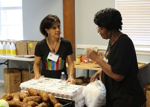 Wellness Director Anamaria Villamarin-Lupin, left, and volunteer Joynell Collins chat during the food pantry on November 7, 2016. The Broadmoor Improvement Association started the food pantry in July 2013 and shortly after partnered with the Broadmoor Community Church. (Photo by Anthony Alongi)